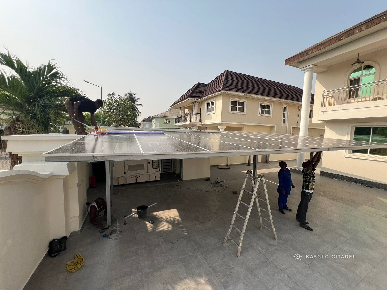 Kayglo crew fitting solar panels onto the carport array at the Ikoyi family residence.