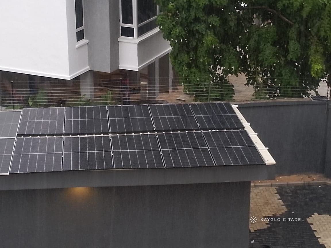 The completed array laid out across the outbuilding roof beside the main house.